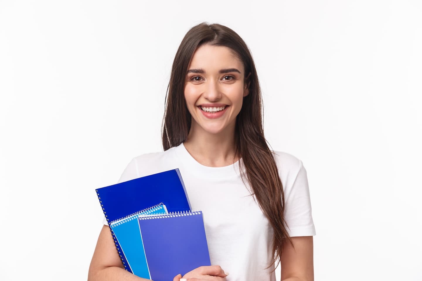 Smiling student holding textbooks and lecture notes
